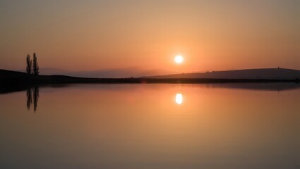 Serene sunset over calm water reflection peaceful dusk landscape silhouettes tranquil scene