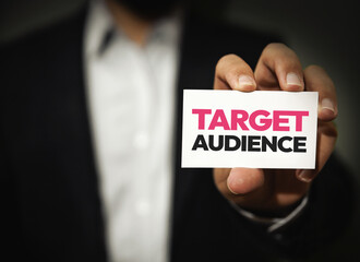 Target Audience typography written on the card shown by a person, close up. business growth, online, marketing concept