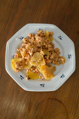 Moussaka, a dish of potatoes and minced meat in a white plate on the table