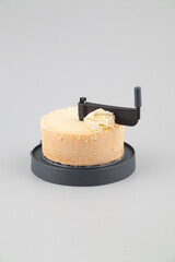 Traditional tete de moine aged mountain cheese on grey background.