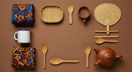 Top view of Indonesian batik fabric with wooden utensils arranged artistically. Perfect for cultural, culinary, and handmade concepts.