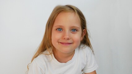Smiling Young Girl Portrait With Blue Eyes In White T-Shirt Against White Background.