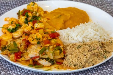 Moqueca capixaba is a typical dish from Espírito Santo, Brazil, made with ocean fish and shrimp. It's cooked gently and flavorfully in a clay pot without the use of palm oil or coconut milk.