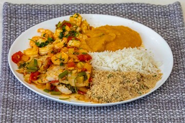 Moqueca capixaba is a typical dish from Espírito Santo, Brazil, made with ocean fish and shrimp. It's cooked gently and flavorfully in a clay pot without the use of palm oil or coconut milk.