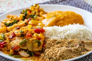 Moqueca capixaba is a typical dish from Espírito Santo, Brazil, made with ocean fish and shrimp. It's cooked gently and flavorfully in a clay pot without the use of palm oil or coconut milk.