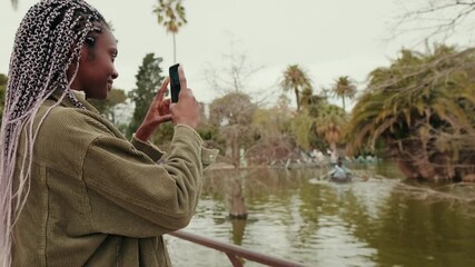 Two women, either best friends or an couple, take photos and enjoy a leisurely day in the park together.