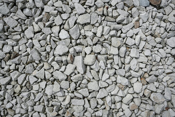 Crushed gray stones arranged closely on a surface ready for construction or landscaping projects