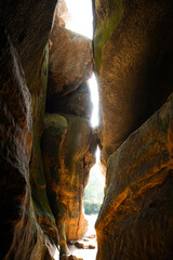 Exploring a narrow canyon with sunlight breaking through in a tranquil outdoor setting
