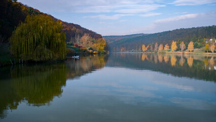Tranquil autumn lake with colorful trees and reflections
Short Description:A calm autumn morning by a peaceful lakeside, where golden-yellow trees reflect vividly in the still water. The misty backgro