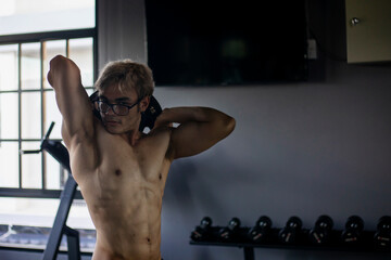 Athletic shirtless handsome young man, muscular young men are exercising with weights in a gym.
