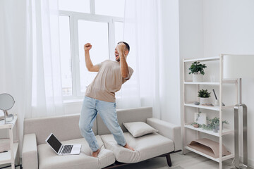 Energetic man celebrating a moment of victory at home, blending personal and work life while...