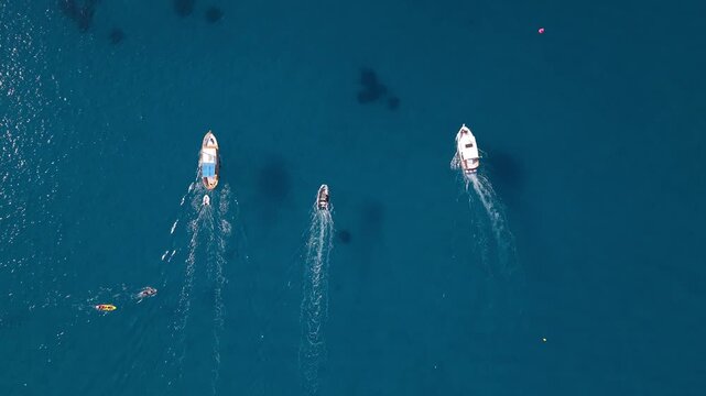 Trois bateaux naviguant c&ocirc;te &agrave; c&ocirc;te vus du ciel au-dessus d&rsquo;une mer bleue