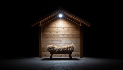 Wooden manger filled with straw illuminated by dramatic overhead lighting in rustic stable setting