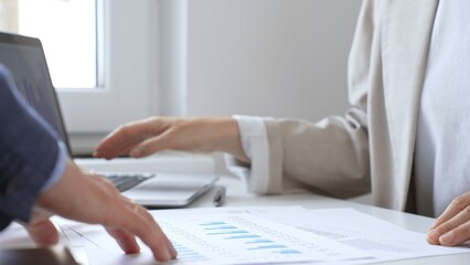 Professional team analyzing financial data, discussing graphs and strategic insights during collaborative workplace meeting. Business people concept