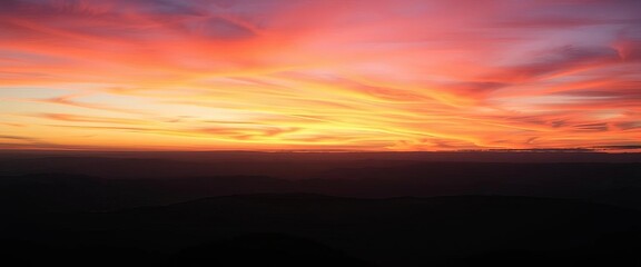 Obraz premium Dramatic twilight sky over silhouetted mountain panorama at nightfall, blue hour, evening