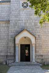 Historic Stone Church Entrance With Arched Doorway and Circular Window Framed by Greenery, Church of St Stephen the First Martyr, Grohote, Solta
