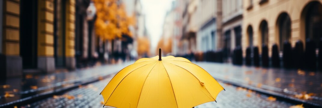 Vibrant yellow umbrella brightens rainy autumn streets in a picturesque city scene