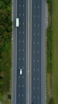 Drone aerial perspective of busy motorway highway with traffic, two lanes, England UK transportation of cars and goods by trucks, road infrastructure 