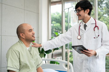 The doctor talks and encourages the patient about treatment options using a digital tablet, promoting clear communication and trust in a bright and supportive hospital environment.