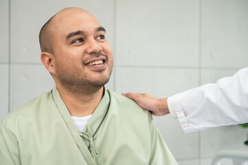 The doctor talks and encourages the patient about treatment options using a digital tablet, promoting clear communication and trust in a bright and supportive hospital environment.