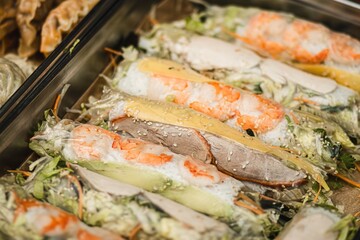 Colorful assortment of fresh spring rolls filled with shrimp, vegetables, and herbs, beautifully arranged on a platter, showcasing vibrant textures and culinary artistry
