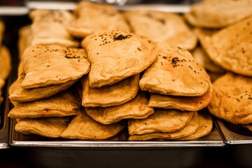 Freshly baked golden pastries stacked neatly on a tray, showcasing a variety of textures and shapes, inviting viewers to explore delicious culinary delights