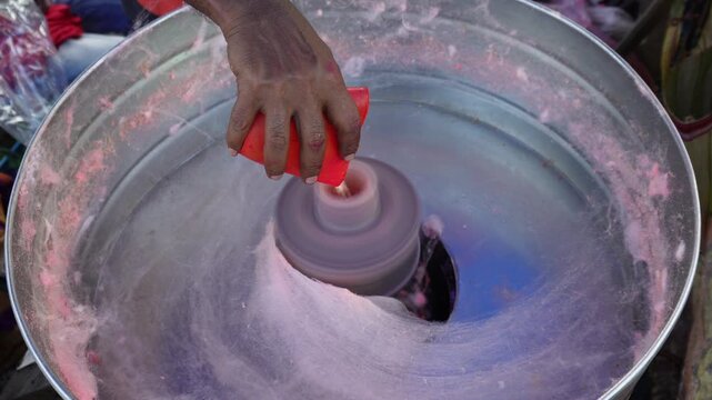 person making cotton candy, also known as candy floss 