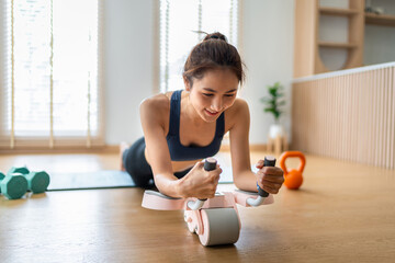 Woman performs core strength exercise ab roller fitness workout home health lifestyle