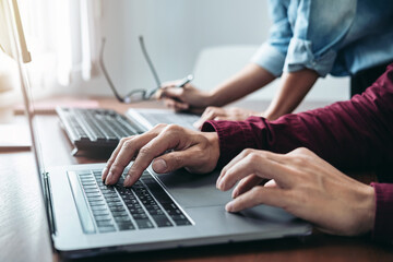 Asian man programmer looking code data on laptop to brainstorming with partner about new project