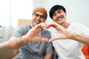 LGBTQIA2S+ couple smile as they build a new life together, a new home, symbolically show love on moving day. A heartwarming moment in our new home, filled with love and understanding.