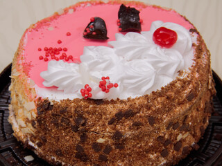 Cherry young Lady cake is a delicious, sweet confection with red, pink, white icing, crumbs and cherries lying on the table