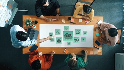 A diverse team engages in a creative brainstorming session around a table covered with colorful notes and ideas, fostering collaboration and innovation in a modern office. Raster