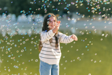 Girl playing with bubbles in a park
