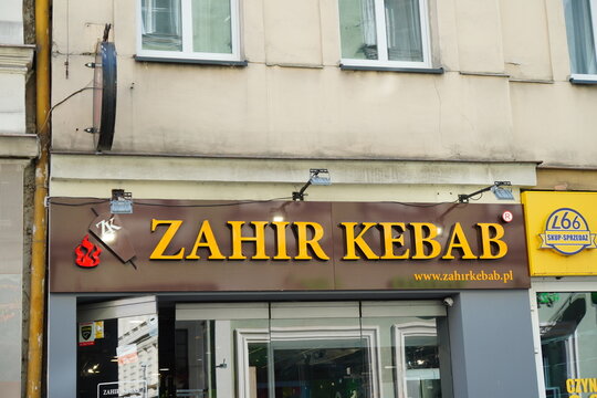 Shopfront of Zahir Kebab eatery with a large sign on a street building showcasing the brand logo and website