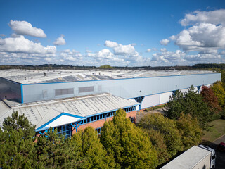 Modern warehouse and distribution depot seen from above with metal cladding, parking bays and...