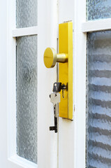 Keys hanging in lock of entrance door close up symbol of security and access