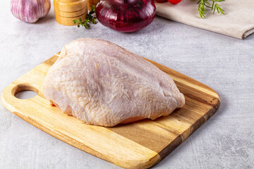 Raw chicken breast with bone and skin