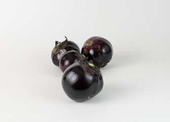 Four round eggplant on a white background