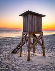 Beach sunrise with wooden lifeguard stand