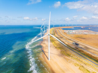 Wind turbine on the seashore. Renewable and natural energy sources. Green energy. Heavy industry. Drone view of wind generators. Waves and beach.