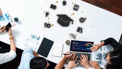 A diverse group of professionals collaborates over a laptop and various charts in a modern office setting, emphasizing data analysis and educational growth. Raster