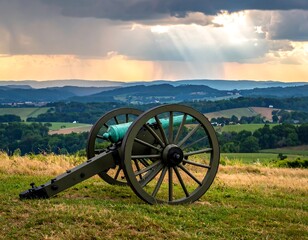 Cannon on hilltop overlooking valley at sunset