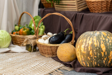 Fresh vegetables and fruits arranged in woven baskets on a textured tablecloth, showcasing a...