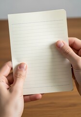 Obraz premium Close-up view of hands holding a lined paper with focus on the texture and details, writing concept