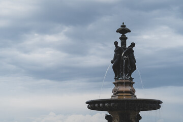 water fountain with two religious figures over clouds