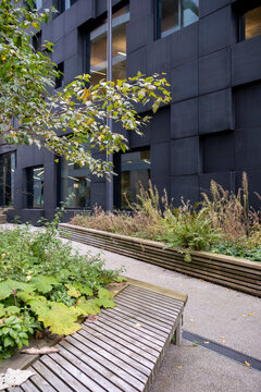 Urban garden with benches among apartment buildings in Oslo Norway, clarity and sustainable Scandinavian green space background for branding and layouts