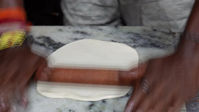 Making chapati bread involves preparing a dough and then rolling it out and cooking it