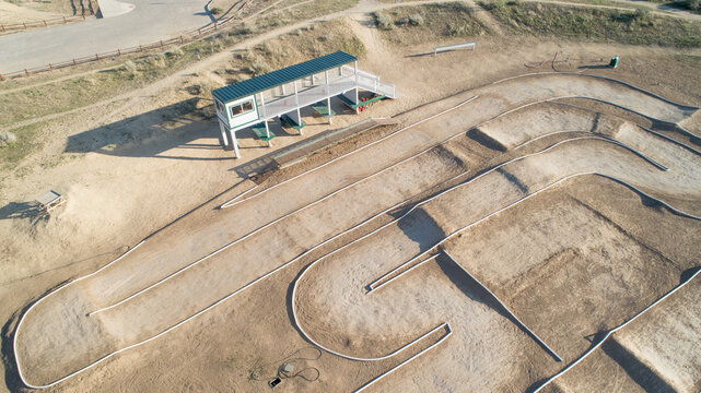 A dirt track with a green and white structure in the middle - Powered by Adobe