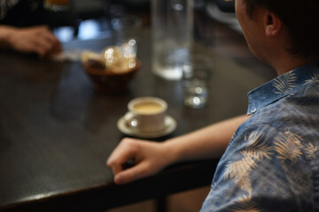 Man sitting at cafe table with cup of coffee