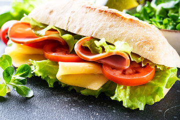 Ciabatta sandwich with lettuce, cheese, tomatoes and ham.